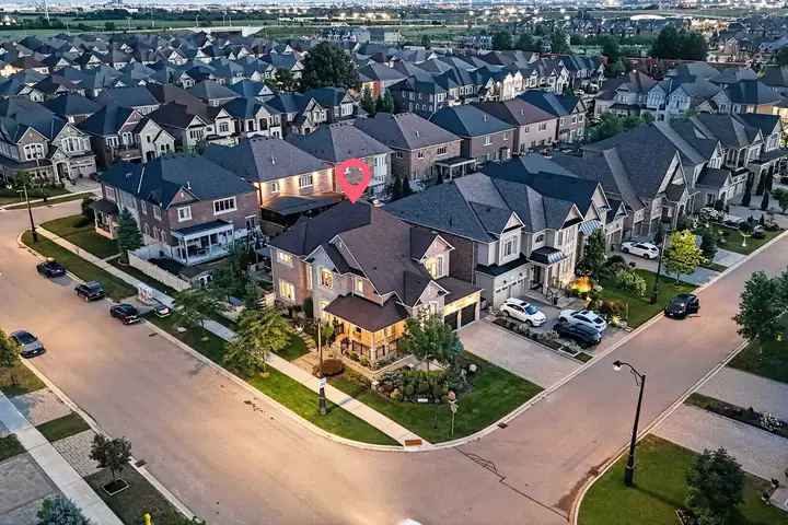 Corner home at dusk from the air, listing marked