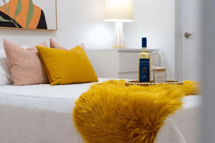 Styled bed with a yellow throw