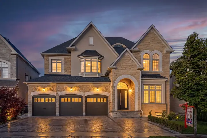 Stone home with a three-car garage at twilight